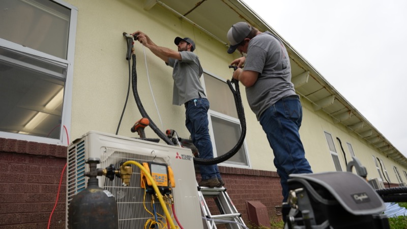 Delta Cooling & Heating technicians working together on HVAC installation in North Louisiana