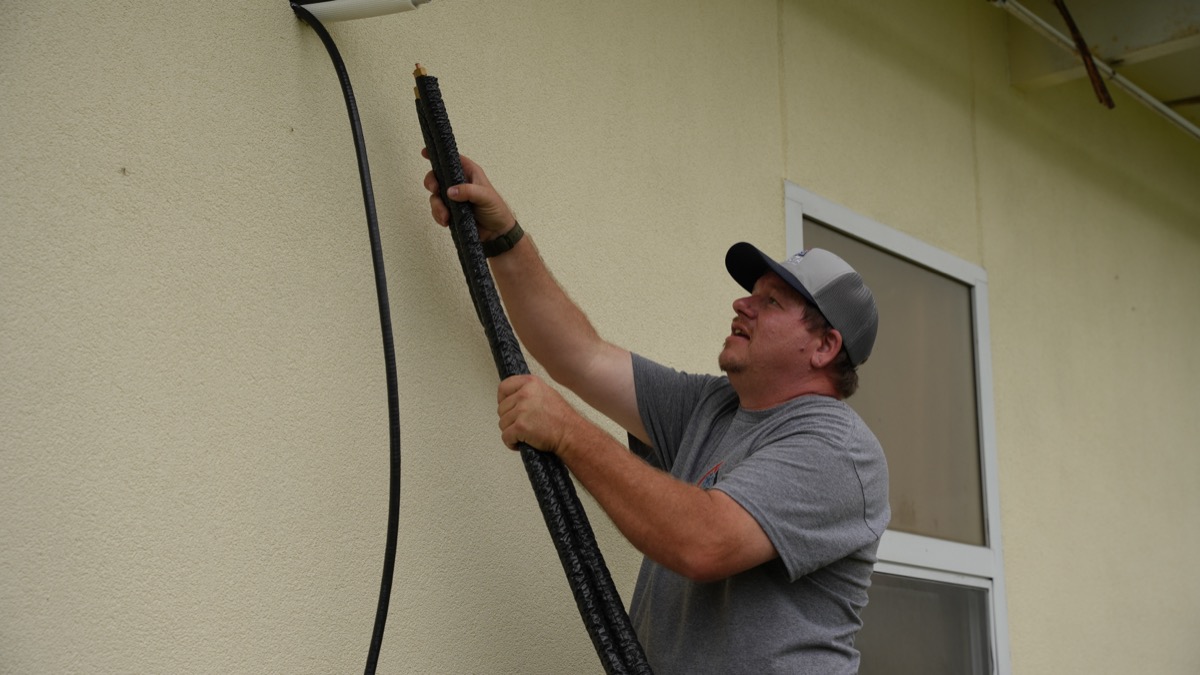 Delta Cooling technician installing AC refrigerant lines in North Louisiana