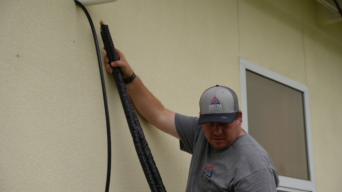 Delta Cooling technician installing heating system refrigerant lines
